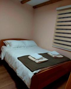 Palanačka Avlija 1 في Ripanj: غرفة نوم عليها سرير وفوط