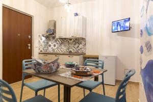 uma cozinha com uma mesa e cadeiras e uma mesa e uma cozinha em Sea Garden Apartments em Ascea