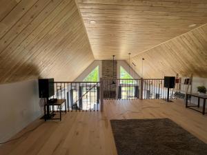 um quarto amplo com tecto e piso em madeira em Chalet Bellevue (Mont-Comi) em Saint-Gabriel