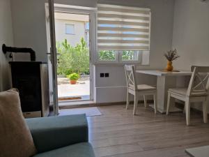 Una sala de estar con un sofá y una mesa y una ventana. en Apartman Jurjević, en Krk