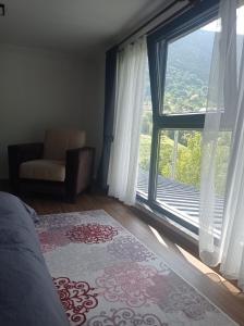 Schlafzimmer mit einem Bett und einem großen Fenster mit Aussicht in der Unterkunft Ayas Apart in Macka