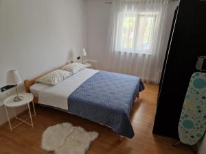 Un dormitorio con una cama, una ventana y un espejo. en Apartman Jurjević, en Krk