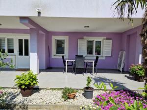Casa morada con mesa y sillas en Apartman Jurjević, en Krk