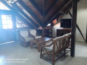 a room with two chairs and a table and a tv at Hotel La Vista in Canoa