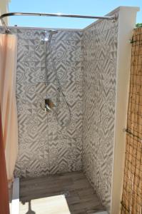 a shower stall in a bathroom with a patterned wall at Casa Vittorina in Pula