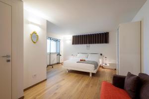 Schlafzimmer mit einem weißen Bett und einem Spiegel in der Unterkunft REVO Apartaments - Gualzi63 the Best View in Sondrio