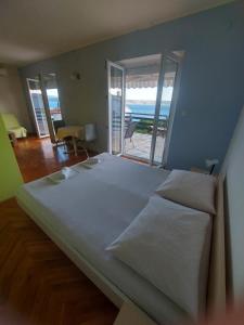 a large bed in a bedroom with a view of the ocean at Apartments Europa in Starigrad
