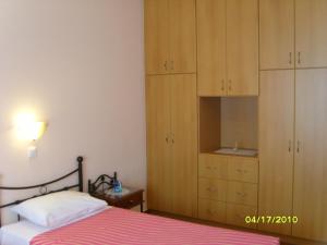 a bedroom with a bed and wooden cabinets at Elisabeth Villas in Kerveli