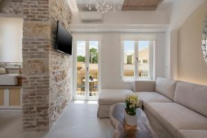 een woonkamer met een bank en een bakstenen muur bij il Campanile Luxury Living in Chania