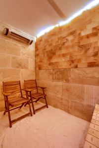 dwa krzesła siedzące w pokoju z kamienną ścianą w obiekcie Słoneczna Willa & sauny w Kudowie Zdroju