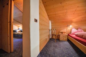 a room with a bed and a desk in a cabin at Agriturismo Apartments Tuene in Ortisei