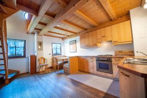 a large kitchen with wooden cabinets and a table at Agriturismo Apartments Tuene in Ortisei