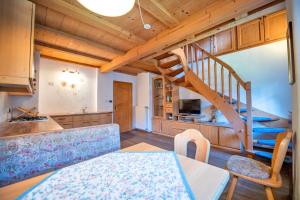 a kitchen and living room with a spiral staircase at Agriturismo Apartments Tuene in Ortisei