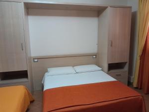 a small bedroom with a bed with an orange blanket at Affittacamere Certe Notti in Sala Consilina