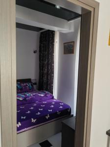 a bedroom with a bed with purple sheets at Apartament 2 dormitoare și living bloc nou in Năvodari