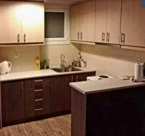 a kitchen with wooden cabinets and a sink at Loutraki by the sea in Loutraki +6 photos