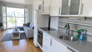 a kitchen with a sink and a couch in a room at Sandnes condo in Sandnes