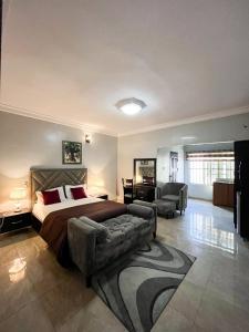 a bedroom with a bed and a couch and a chair at Bronx Suite by Jaynice Homes in Lekki
