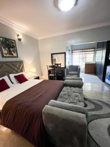 a bedroom with a large bed and a chair and a desk at Bronx Suite by Jaynice Homes in Lekki