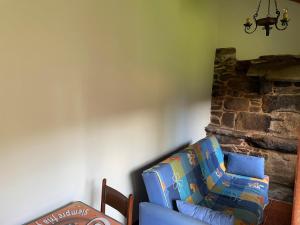 un soggiorno con divano blu e parete in pietra di Casa de Guimarás. 