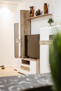 a living room with a tv on a white wall at Apartment Neiv in Tivat