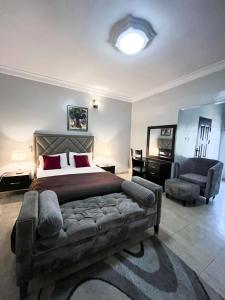 a bedroom with a large bed and a chair at Bronx Suite by Jaynice Homes in Lekki