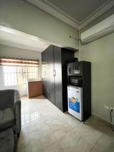 a room with a kitchen with a microwave and a refrigerator at Bronx Suite by Jaynice Homes in Lekki