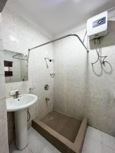 a bathroom with a sink and a shower with a mirror at Bronx Suite by Jaynice Homes in Lekki