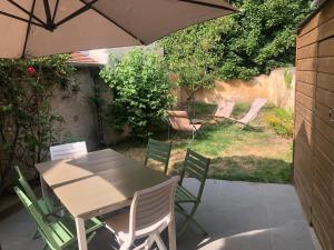 a table and chairs with an umbrella on a patio at L'Echoppe en ville in Amboise