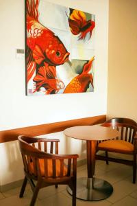 a table and two chairs and a painting on the wall at Holiday Inn Huatulco, an IHG Hotel in Santa Cruz Huatulco