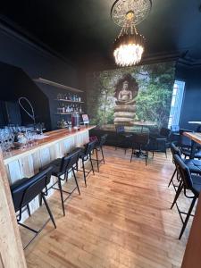 a bar with chairs and a large painting on the wall at AUBERGE et BISTRO NAMASTÉ in Lachute