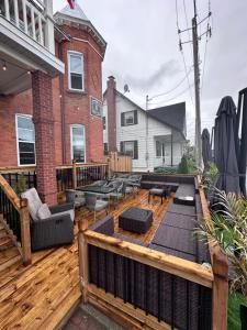 eine Holzterrasse mit Möbeln auf einem Haus in der Unterkunft AUBERGE et BISTRO NAMASTÉ in Lachute