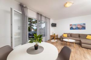 uma sala de estar com uma mesa branca e um sofá em Apartment LaPePa em Šilo