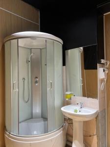 een badkamer met een douche en een wastafel bij Capsule Hostel in Karakol