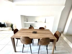 a dining room with a wooden table and chairs at Coquette maison climatisée in Pechbonnieu