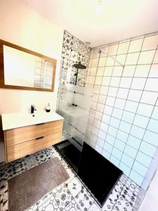 W łazience znajduje się prysznic, umywalka i lustro. w obiekcie Coquette maison climatisée w mieście Pechbonnieu