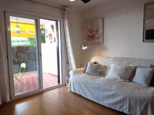 een slaapkamer met een wit bed en een glazen schuifdeur bij El Refugio Paz y Tranquilidad Benalmadena Costa del Sol in Benalmádena