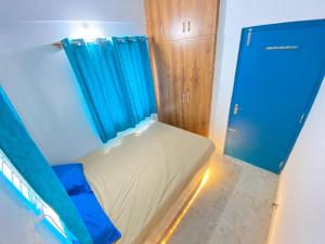 una piccola camera con letto e tenda blu di Shree 269 a Bangalore