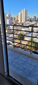 balcón con vistas a una ciudad con palmeras en Departamento temporal por día y/o semana en Bahía Blanca