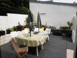 a patio with a table and chairs and an umbrella at spacieux T5 Quimper centre in Quimper