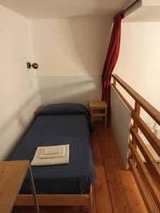 Habitación pequeña con cama y escalera en Il Castello Apartment en Nápoles