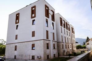 a large white building with windows on the side of it at Apartment Neiv in Tivat