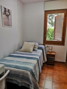 1 dormitorio con cama y ventana en Apartamento con piscina L' Áncora en Calella de Palafrugell