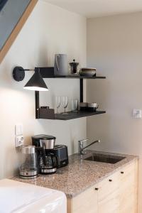 a kitchen counter with a sink and shelves at Billnäsin ruukki in Billnäs