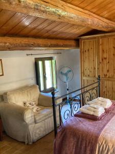 1 dormitorio con cama, sofá y ventana en Il Nascondiglio - The Hideaway, en Amandola