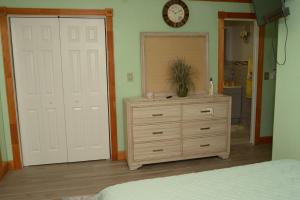 a bedroom with a dresser and a clock on the wall at Cottage by Jubilee in Freeport