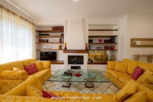 uma sala de estar com sofás amarelos e uma mesa de vidro em Casa Yubi by PortofinoVip em Santa Margherita Ligure