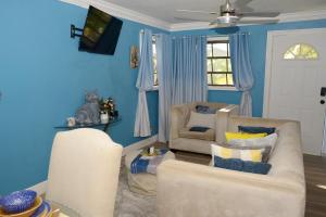 a living room with blue walls and two chairs at Cottage by Jubilee in Freeport