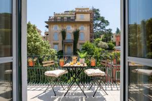 uma mesa e cadeiras fora de uma janela com um edifício em Casa Yubi by PortofinoVip em Santa Margherita Ligure