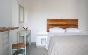 a white bedroom with a white bed and a desk at Firoa Studios in Donoussa